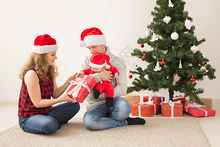 快乐的一对夫妇与婴儿 一起庆祝圣诞节在家里 女孩 成人图片