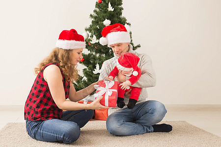 快乐的一对夫妇与婴儿 一起庆祝圣诞节在家里 儿子 夫妻图片