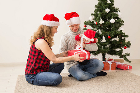 快乐的一对夫妇与婴儿 一起庆祝圣诞节在家里 房间 冬天图片