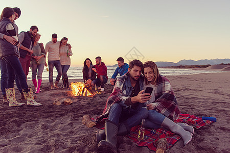 在海滩上和朋友一起享受营火的情侣 篝火 火焰图片