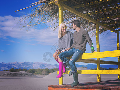 年轻情侣在海滩上一起喝啤酒 假期 空的 吃 野餐图片