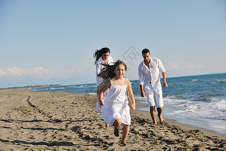 快乐的年轻家庭在海滩上玩得开心 闲暇 孩子 笑图片