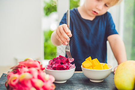 小可爱男孩在阳台上吃芒果 异国情调 水果 夏天图片