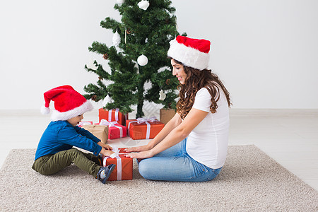 圣诞节 单身父母和假期概念 — 可爱的小男孩在家里为他的母亲拿着圣诞礼物 房间 传统图片