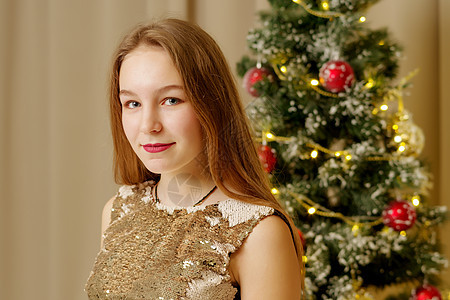 有个十几岁的女孩坐在新年树附近 圣诞老人 庆典 房间图片