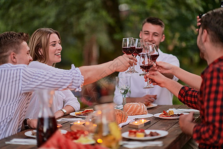 朋友在户外野餐宴会边喝红酒 一边烤红酒杯 食物 微笑图片