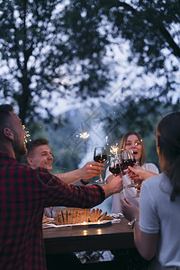 朋友在户外野餐宴会边喝红酒 一边烤红酒杯 男性 夏天图片