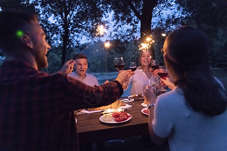 朋友在户外野餐宴会边喝红酒 一边烤红酒杯 假期 团体图片