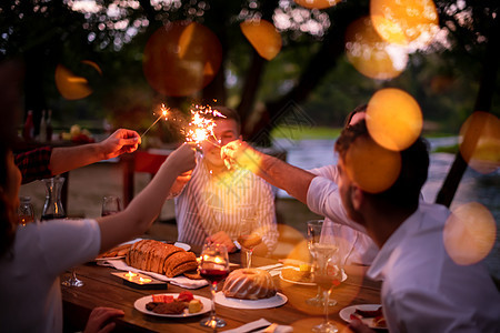 快乐的朋友们在户外举行法国晚餐晚宴 野餐 派对图片