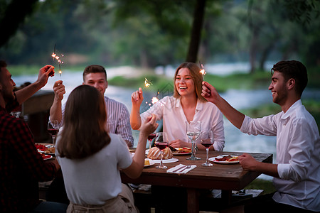 快乐的朋友们在户外举行法国晚餐晚宴 生日 食物图片