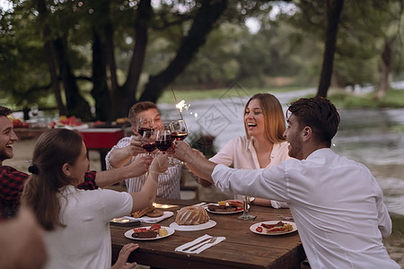 朋友在户外野餐宴会边喝红酒 一边烤红酒杯 多样性 午餐图片