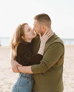 年轻成年夫妇站在沙滩上 互相看对方图片