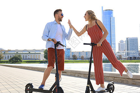 可爱的情侣在城市长廊上驾驶电动滑板车玩得开心 男人 女士图片