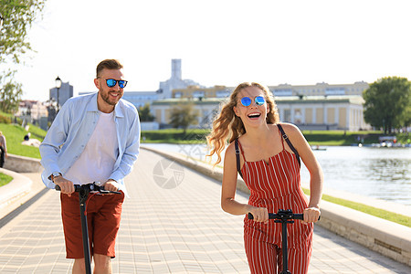 可爱的情侣在城市长廊上驾驶电动滑板车玩得开心 微笑 户外图片