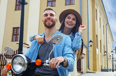 快乐的年轻夫妇骑着摩托车在城里 帅哥和年轻女子旅行 冒险和度假概念 路 朋友们图片