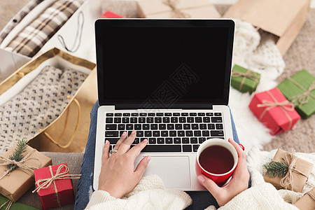 妇女在笔记本电脑上买礼物和喝咖啡 复制空间图片