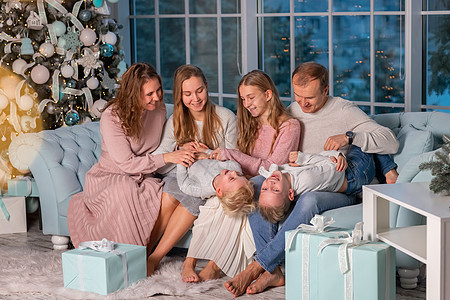 大家庭快乐 有很多孩子在圣诞节前夕 在圣诞树附近的沙发上玩得开心的 幸福 冬天图片