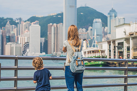 年轻女子和她的儿子在中国香港维多利亚港拍照图片