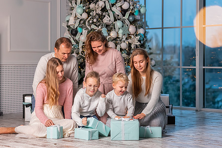 快乐的大家庭 有很多孩子在圣诞前夕在圣诞树下打开礼物 姐姐 乐趣图片