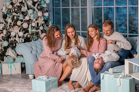 大家庭快乐 有很多孩子在圣诞节前夕 在圣诞树附近的沙发上玩得开心的 客厅 盒子图片