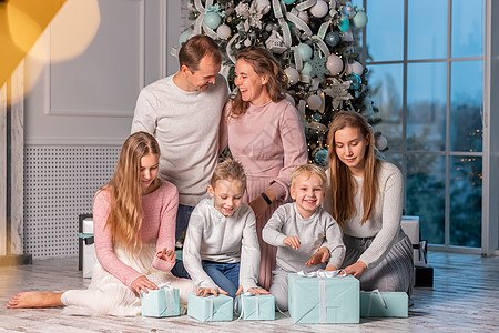 快乐的大家庭 有很多孩子在圣诞前夕在圣诞树下打开礼物 父亲 圣诞老人图片