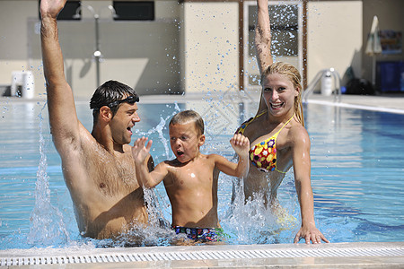快乐的年轻家庭 在游泳池玩得开心 假期 夏天图片