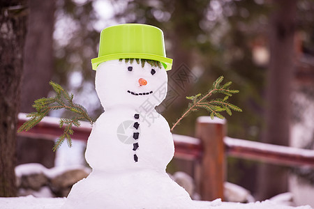 带着绿色帽子微笑的雪人 冬天 降雪 寒冷 好玩的 场景图片