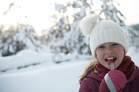 可爱的小女孩 在美丽的冬日吃冰棒时 降雪 微笑图片