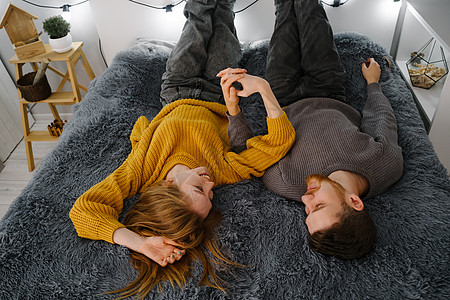 一对情侣躺在床上 带着一条灰色毛毯图片