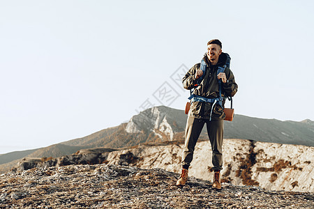 年轻的天主教男子旅行者 在山上徒步旅行 背着大背包在山上远足 日出 攀登图片