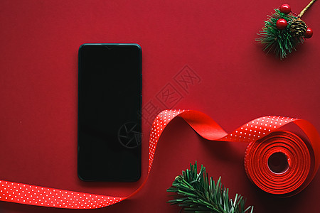 带有空白黑屏幕的智能手机和红色背景的Xma装饰 作为平板假造模型设计 c 用于使用普通 技术 新年图片