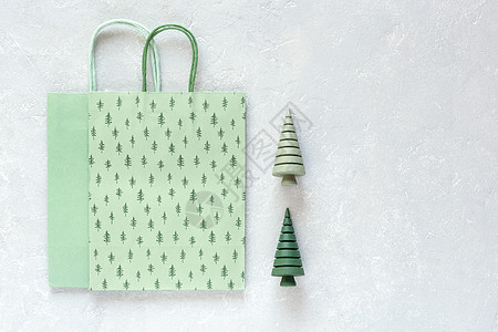 绿色的圣诞纸袋和灰色背景的木木圣诞树图片