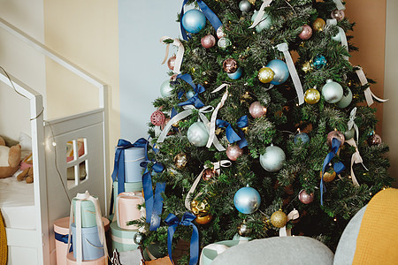 圣诞树上有蓝色和金色的玩具 客厅里的圣诞树 装饰着蓝色饰品和花环 树下有很多礼物 冬季假期 冷杉 购物图片