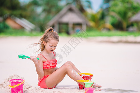 在热带度假期间玩沙滩玩具的可爱小女孩 热带假期 海景 自然图片