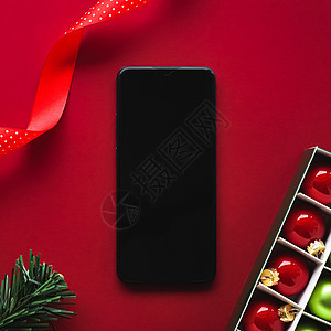 带有空白黑屏幕的智能手机和红色背景的Xma装饰 作为平板假造模型设计 c 用于使用普通 新年 假期图片