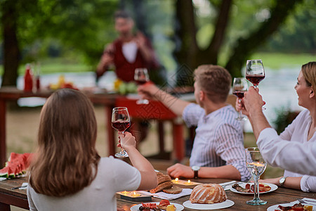 朋友在户外野餐宴会边喝红酒 一边烤红酒杯 朋友们 花园图片