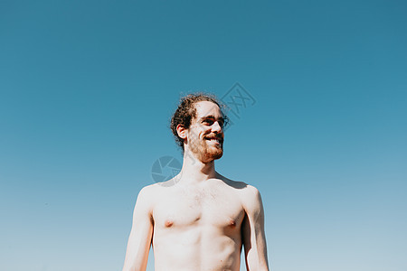 年轻人在沙滩上光着膀子 清晰的背景 自由自信的概念 假期 胡须和长发图片