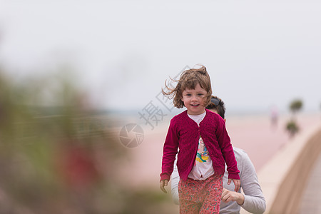 母亲和可爱的小女孩 在海边的赛道上 乐趣 女儿图片