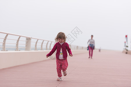 母亲和可爱的小女孩 在海边的赛道上 家庭 夏天图片