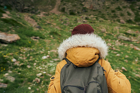 穿着黄色外套在山上徒步旅行的女子之旅图片