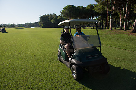 赛道上驾驶推车的高尔夫球运动员 旅游 夫妻 玩家图片