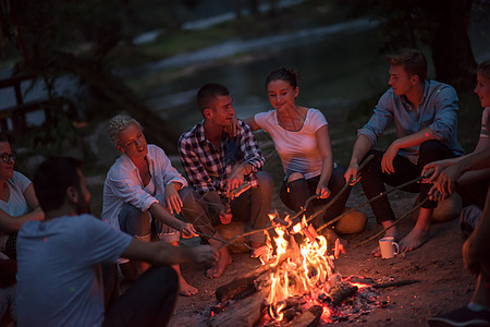 年轻朋友在营火周围放松 派对 享受 吉他 朋友们 女士图片