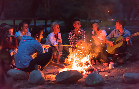 年轻朋友在营火周围放松 喝 户外 野餐 篝火 家庭图片