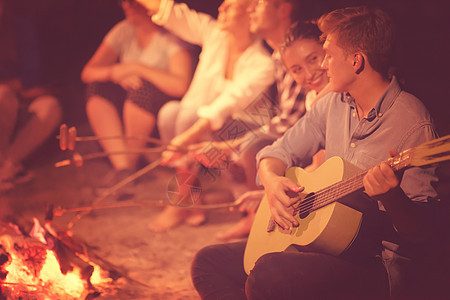 年轻朋友在营火周围放松 火焰 晚上 旅行 朋友们 户外图片