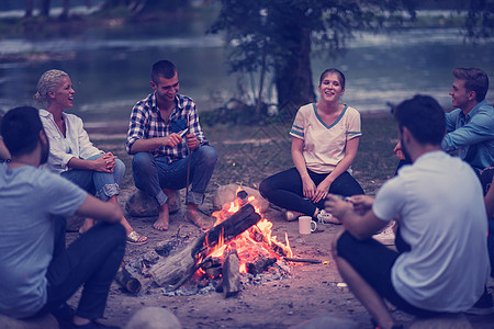 年轻朋友在营火周围放松 野餐 女士 旅游 假期 野营图片
