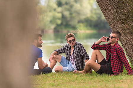 坐在河岸边的男子 户外 草地 游客 坐着 天 公园图片