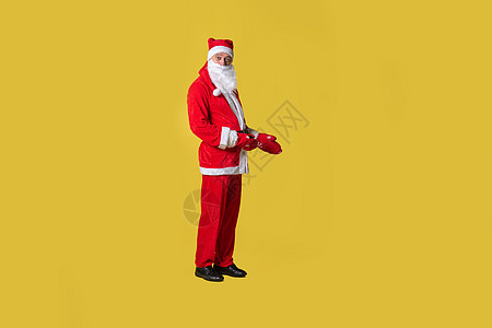 圣诞老人黄色食品时尚 吊带节日新年 有趣的旧 帽子留着欢快的胡子 时间的手不停地展示图片