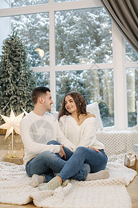 圣诞前夜 英俊的男孩和他漂亮的女朋友在家里互相拥抱 适合树和雪 outsif 圣诞心情 家庭 冬天图片