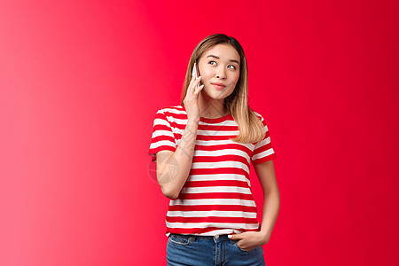 你好 我要订单 可爱的现代金发亚洲女孩打电话拿着智能手机按下耳朵看起来梦幻般地微笑着高兴 女人有有趣的谈话 等人接听电话 小工具图片