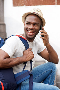 带着手提电话的袋子说话的年轻非裔美国人笑着微笑的人图片